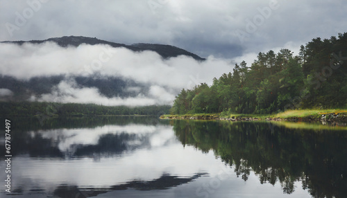 beautiful lake in misty morning forest and clouds are reflected in the calm water surface norwegian landscape with dark forest and lake among low clouds nature ecology eco tourism