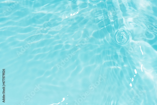 Defocus blurred transparent blue colored clear calm water surface texture with splashes reflection. Trendy abstract nature background. Water waves in sunlight with copy space. Blue watercolor shine.