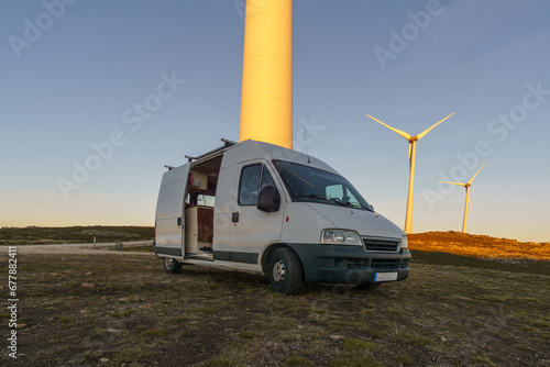 Wind turbines at Serra da Arada over mountain landscape at evening sunset with camper van in foreground, Sao Pedro do Sul, Portugal photo