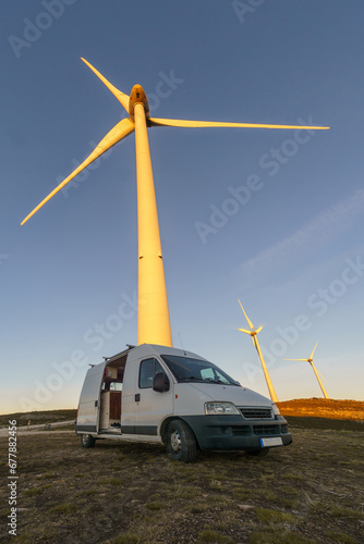 Wind turbines at Serra da Arada over mountain landscape at evening sunset with camper van in foreground, Sao Pedro do Sul, Portugal photo