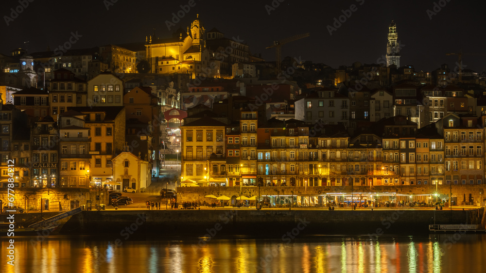 Night view at Ribeira do Porto with reflection of lights on water surface of Douro River seen from Vila Nova de Gaia, Porto, Portugal