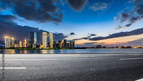 asphalt road and city skyline with modern building at night in suzhou china