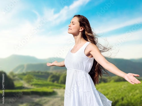 Happy young woman breathing air in a park