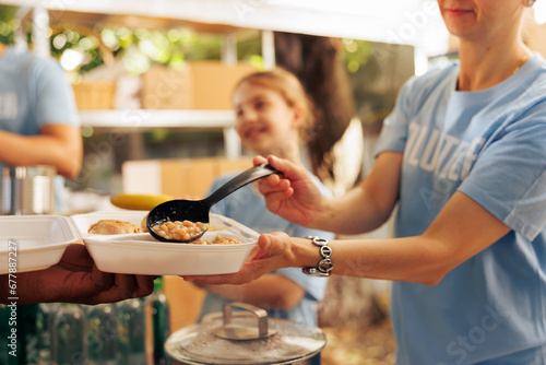 Tableau sur toile Close-up shot of caucasian charity worker providing fresh warm meal from an outdoor food bank to a person in need