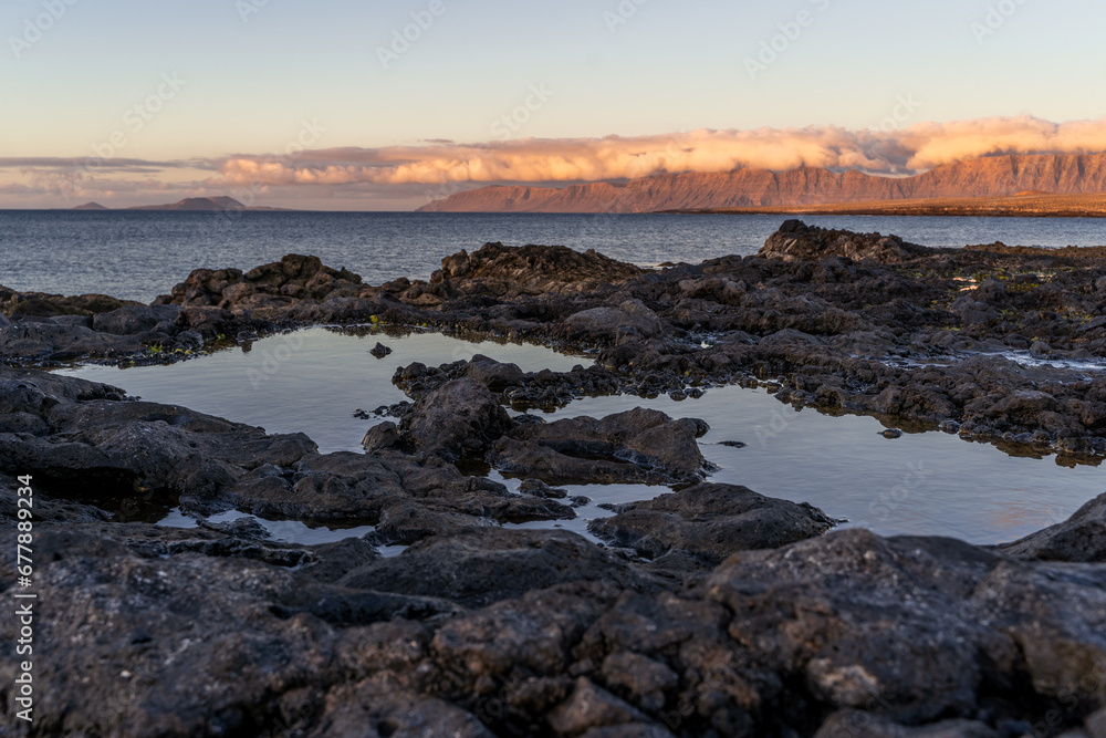 View of famara cliffs at sunset with ocean pools in the foreground, lanzarote