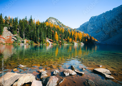 Picturesque view on Blue Lake. Autumn mountains landscape with Blue Lake and bright orange larches in the North Cascades National Park in Washington State, USA.	
