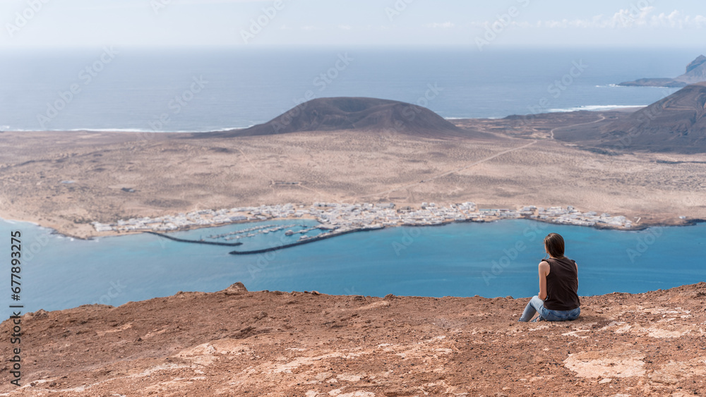 Girl lookin at the Graciosa Island, relaxing and meditating high above the ocean, Lanzarote, Canary Islands Girl lookin at the Graciosa Island, relaxing and meditating high above the ocean, Lanzarote, Canary Islands