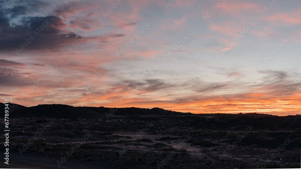 Obraz premium Sunset with red fire clouds and pink hues on the ocean with volcanos, skyline peace beauty nature environment idillyc beautiful beach