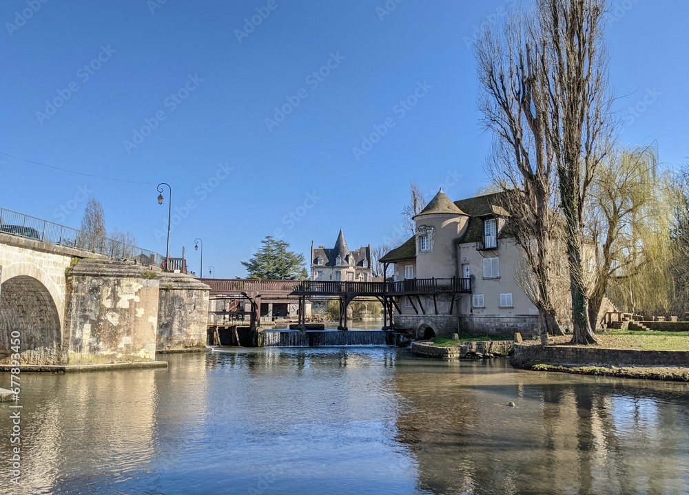 Scenic shot of Loing River and old historic buildings around under the blue sky