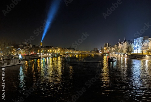 Illuminated cityscape view with Pont Neuf bridge and river Seine at night, Paris, France