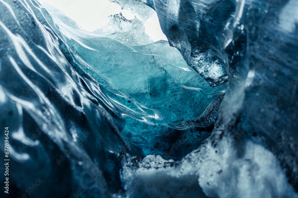 Frozen ice cap in vatnajokull caves melting due to global warming, frosty icelandic rocks forming massive crevasse and glacier hiking tunnels. Transparent glacial texture on cracked ice blocks.