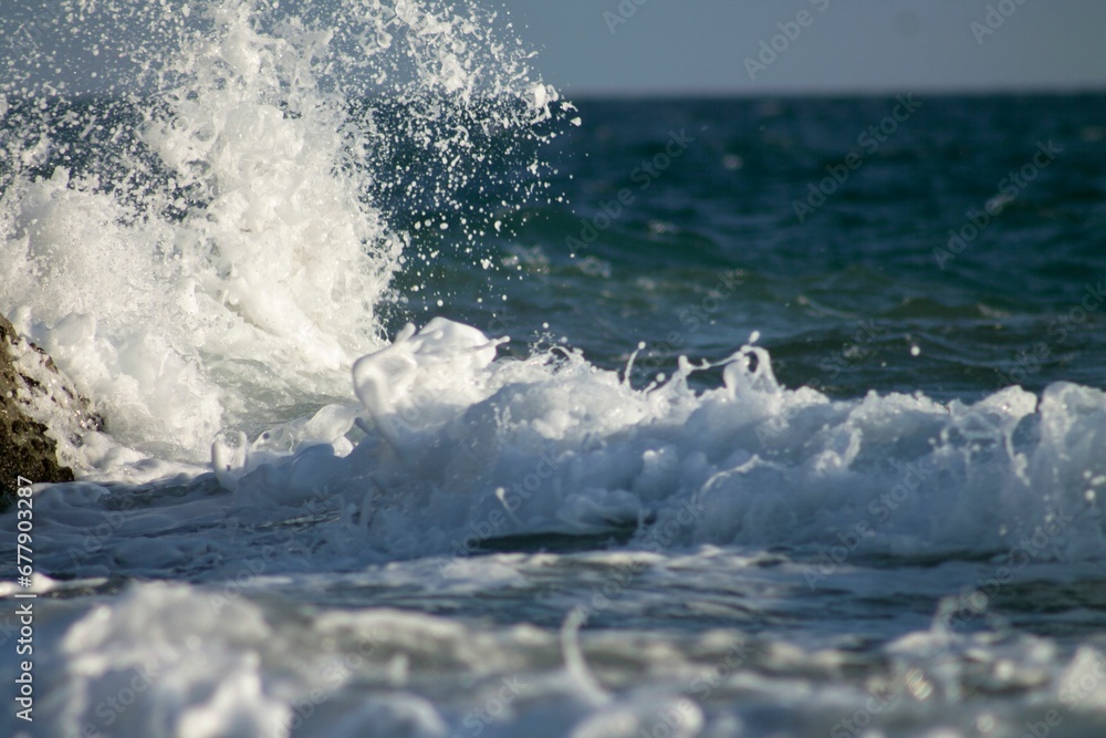 Scenic view of sea waves foaming and crashing against the beach on a sunny day Scenic view of sea waves foaming and crashing against the beach on a sunny day