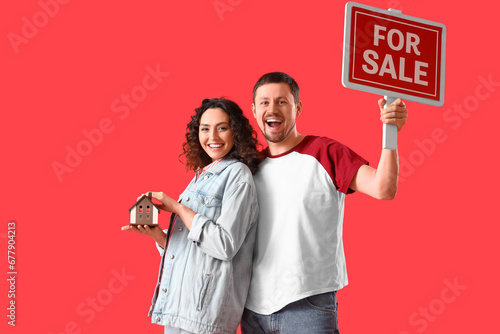 Happy couple holding miniat...