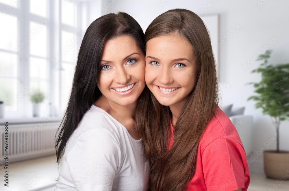 Kind optimistic woman hugging teenage daughter Kind optimistic woman hugging teenage daughter