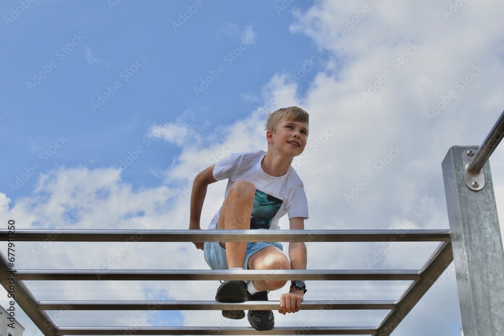 boy on the horizontal bar at the playground