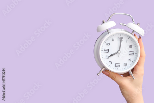 Hand holding white alarm cl...
