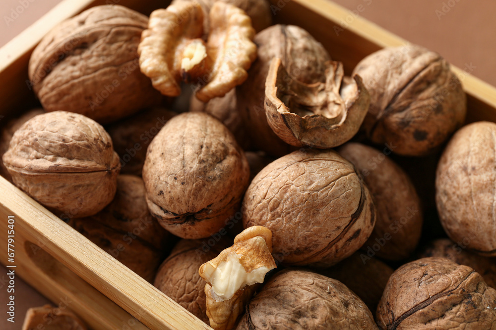 Wooden box of tasty walnuts on brown background, closeup Wooden box of tasty walnuts on brown background, closeup
