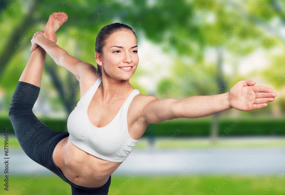 Fototapeta premium Young sporty woman stretching in park