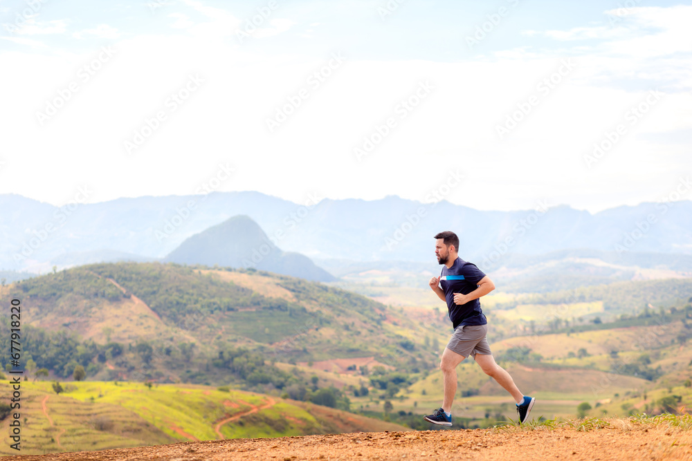 A man running outdoors amid a beautiful landscape. An image to inspire sports and wellness. Excellent for sports events campaigns