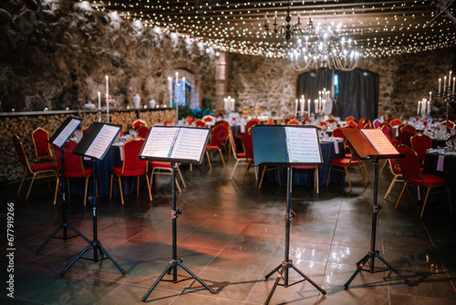 empty concert hall with round tables chairs and musical scores before a symphony orchestra performance photo