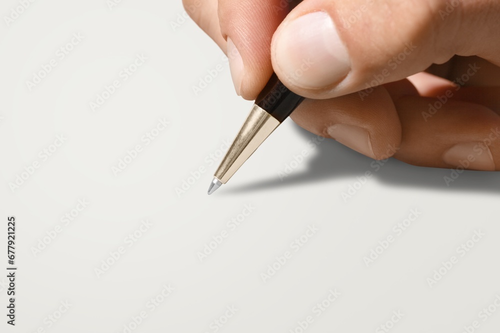 Human hand holding a pen on gray background Human hand holding a pen on gray background