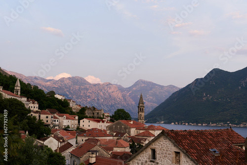 View over the roofs of old houses on the bell tower of the church on the seashore. Perast, Montenegro