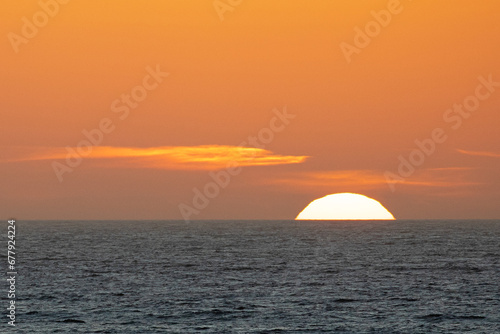 Setting sun sinking into the horizon at San Simeon California United States