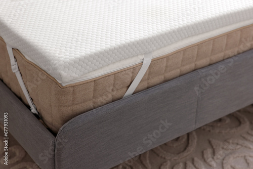 White memory foam mattress topper on grey bed