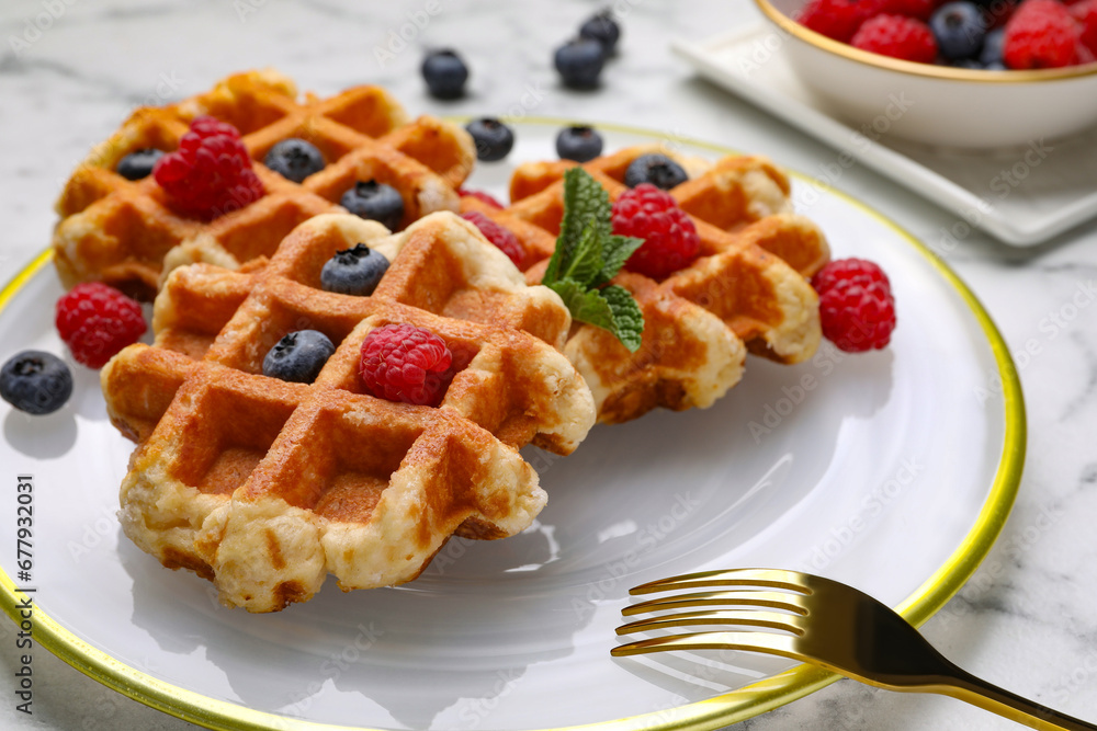 Delicious Belgian waffles with fresh berries and mint on table, closeup Delicious Belgian waffles with fresh berries and mint on table, closeup