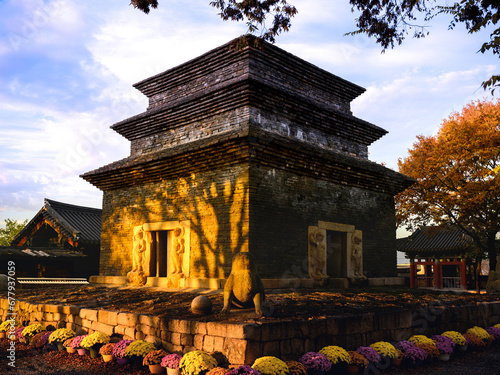 Gyeongju City landmark Bunhwangsa Buddhist Temple, 1,500 year old heritage preservation site, in South Korea, the oldest remaining stone tower with golden sun rays illuminating the walls at sunrise photo