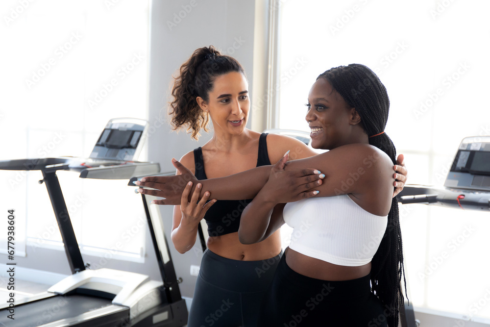 Coach or instructor training woman workout with warm up and stretch muscle arm in fitness gym, woman in sportswear practicing exercise with sport with trainer, sport and motivation for health. Coach or instructor training woman workout with warm up and stretch muscle arm in fitness gym, woman in sportswear practicing exercise with sport with trainer, sport and motivation for health.