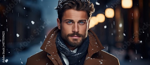 In the isolated wintry background a fashionably dressed man is captured by the cameras lens his face adorned with a happy smile reflecting the success and confidence exuded in his portrait a photo