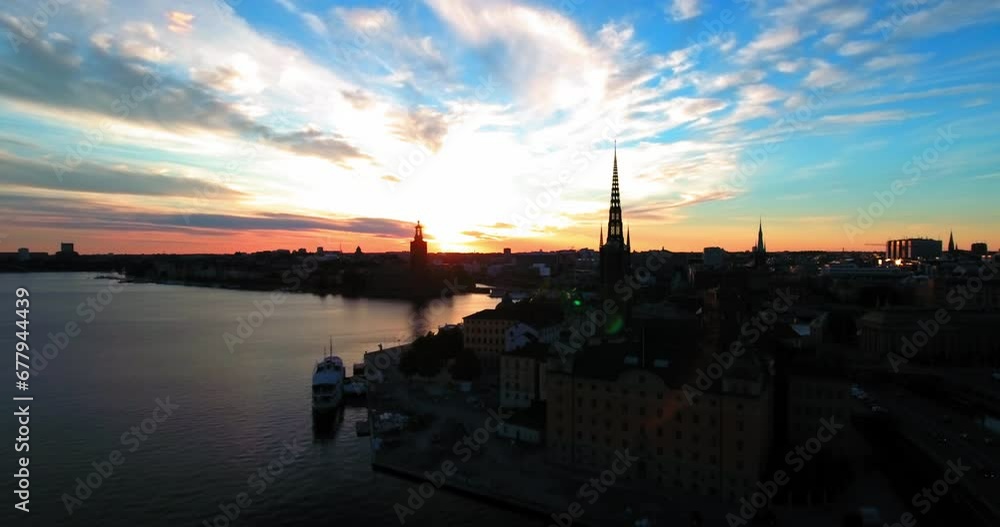 Aerial Forward: Houses And Buildings By River In City During Sunset Against Sky - Stockholm, Sweden Aerial Forward: Houses And Buildings By River In City During Sunset Against Sky - Stockholm, Sweden