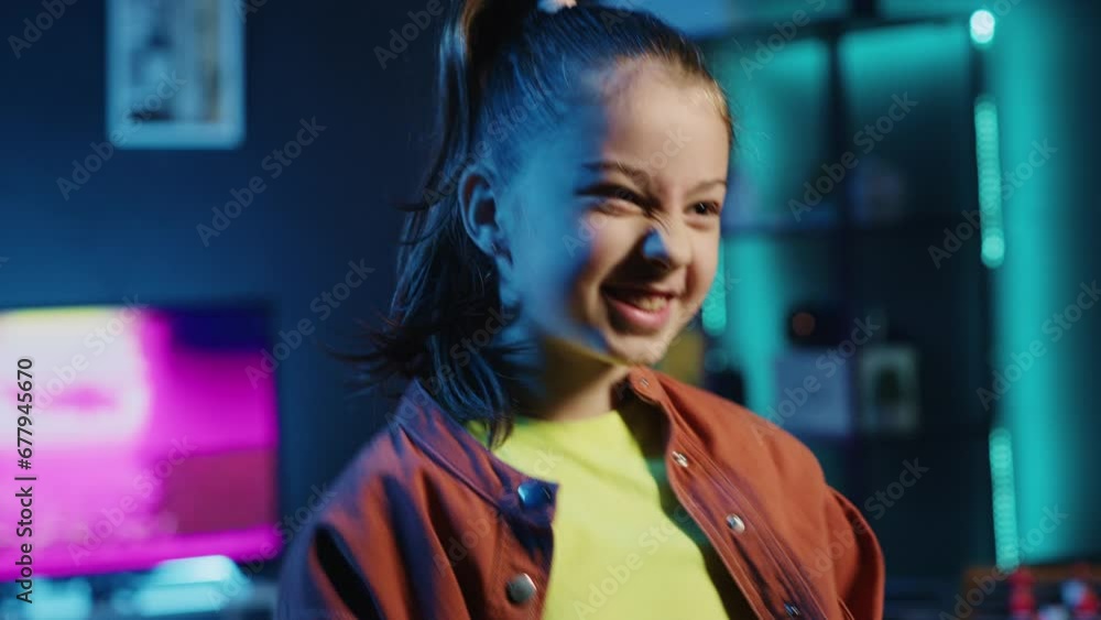 Close up shot of smiling kid dancing in dimly lit home studio interior, producing content for online channel. Excited child doing viral dance choreography in apartment illuminated by neon lights Close up shot of smiling kid dancing in dimly lit home studio interior, producing content for online channel. Excited child doing viral dance choreography in apartment illuminated by neon lights