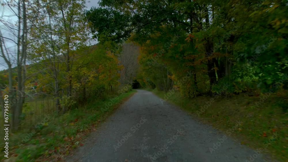 Drone flying low over a country gravel road in the mountains during fall. Drone flying low over a country gravel road in the mountains during fall.