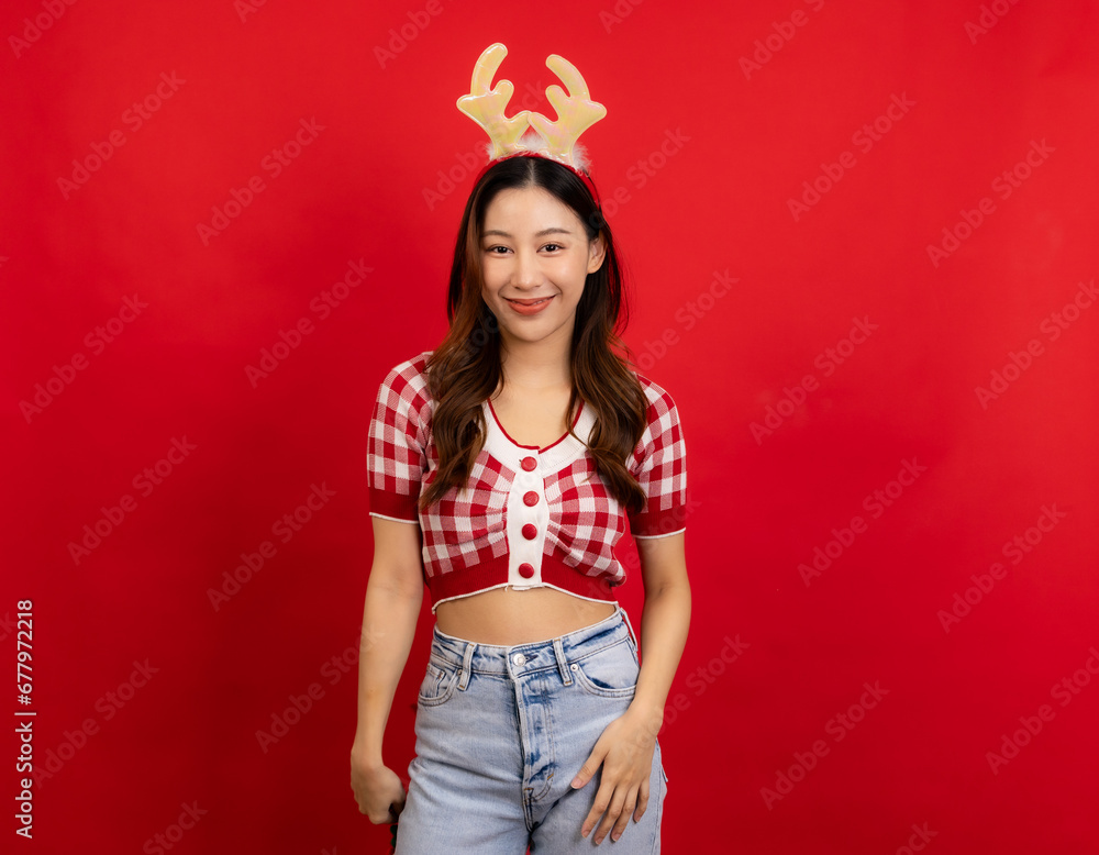 Young asianwoman wears green clothes Santa hat hold open shopping package bags isolated on red background. Young asianwoman wears green clothes Santa hat hold open shopping package bags isolated on red background.