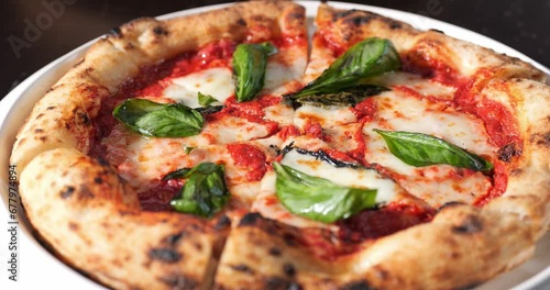 Margherita pizza with mozzarella cheese, tomato sauce, olive oil and basil leaves.