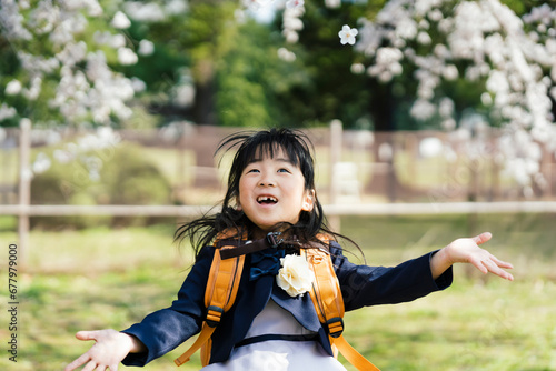 桜を見上げる小学生の女の子 photo