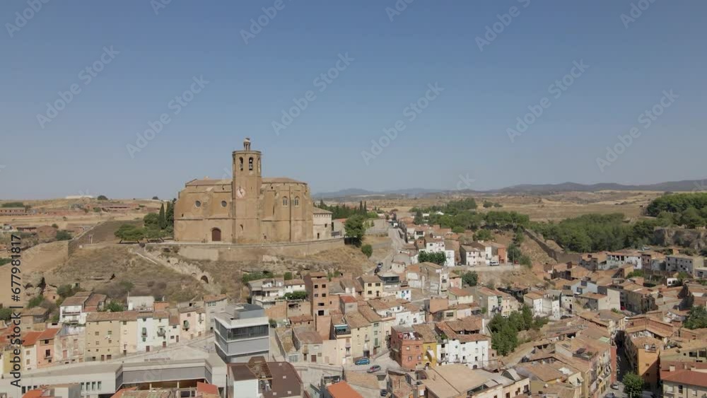 An enchanting circular drone shot of the Catholic Church Santa Maria de Balaguer in Lleida, Spain, basking in the golden afternoon sun An enchanting circular drone shot of the Catholic Church Santa Maria de Balaguer in Lleida, Spain, basking in the golden afternoon sun