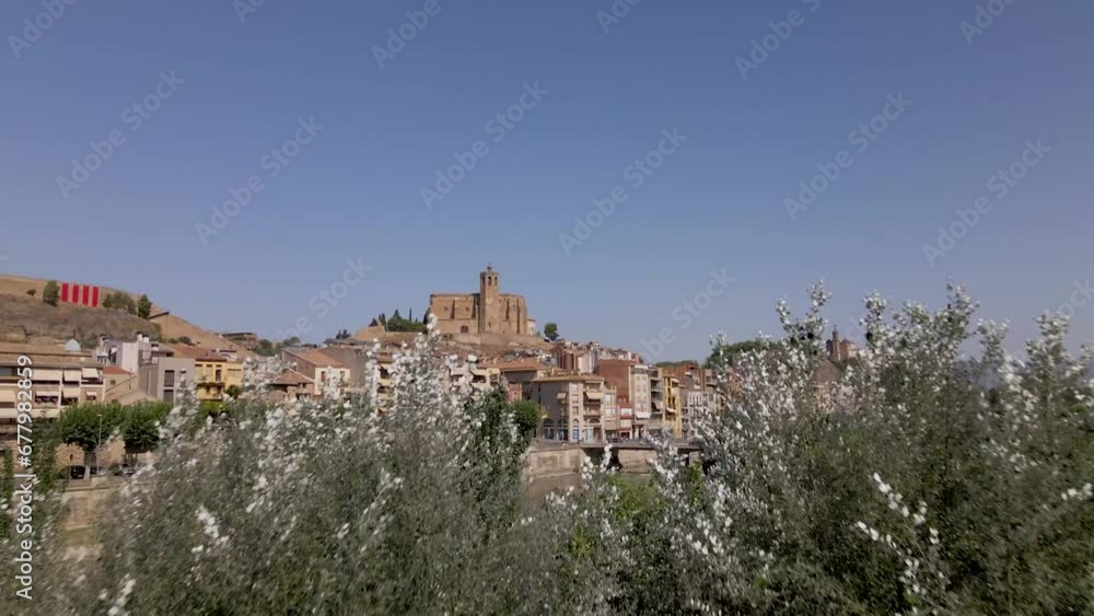 A captivating drone reveal of the Catholic Church Santa Maria de Balaguer in Lleida, Spain, bathed in the warm afternoon sun A captivating drone reveal of the Catholic Church Santa Maria de Balaguer in Lleida, Spain, bathed in the warm afternoon sun