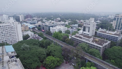 A View from above an office building of a rooftop terrace and metro train track Within those buildings and A residential apartment complex is located in the vicinity. photo