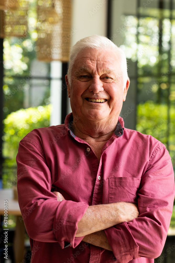 Portrait of happy caucasian senior man standing with arms crossed smiling in sunny kitchen at home Portrait of happy caucasian senior man standing with arms crossed smiling in sunny kitchen at home