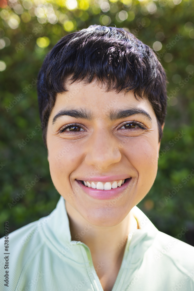 Portrait close up of happy biracial woman with short dark hair smiling in sunny garden Portrait close up of happy biracial woman with short dark hair smiling in sunny garden