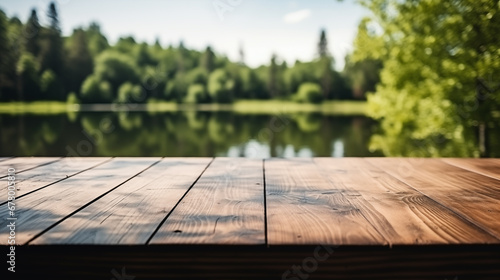 Leere, rustikale Holztischplatte mit einem See und Wald im Sommer im Hintergrund, Platz für Warenpräsentation oder Text photo