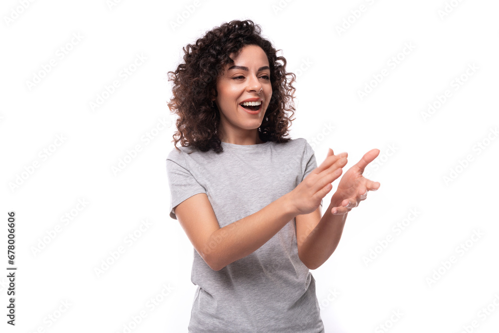 portrait of a pretty young european slim brunette woman with curly hair dressed in a gray t-shirt on a white background portrait of a pretty young european slim brunette woman with curly hair dressed in a gray t-shirt on a white background