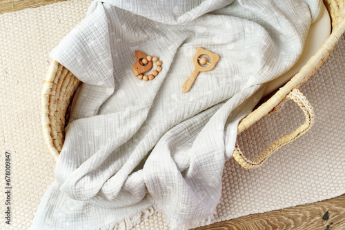 Muslin blanket and wooden toys in baby cradle