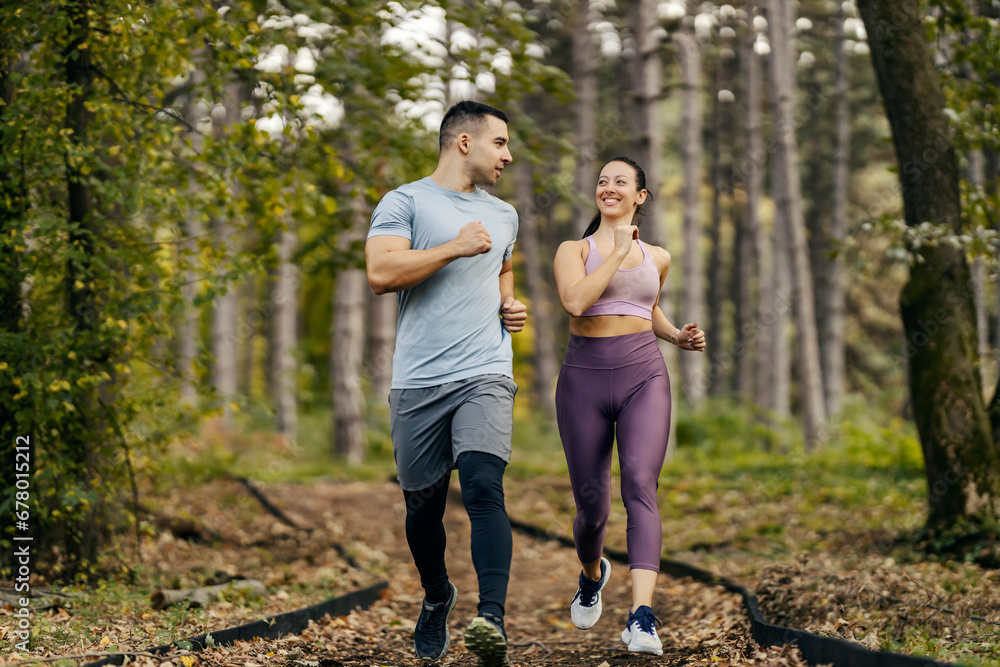 Nature fitness. A happy sporty couple is running in woods. Nature fitness. A happy sporty couple is running in woods.