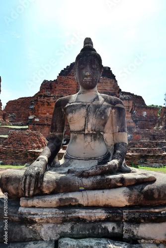 Old Buddha statue in Thailand ancient temple with historical building background