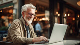 Senior male freelancer working on laptop in cafe. remote work concept.