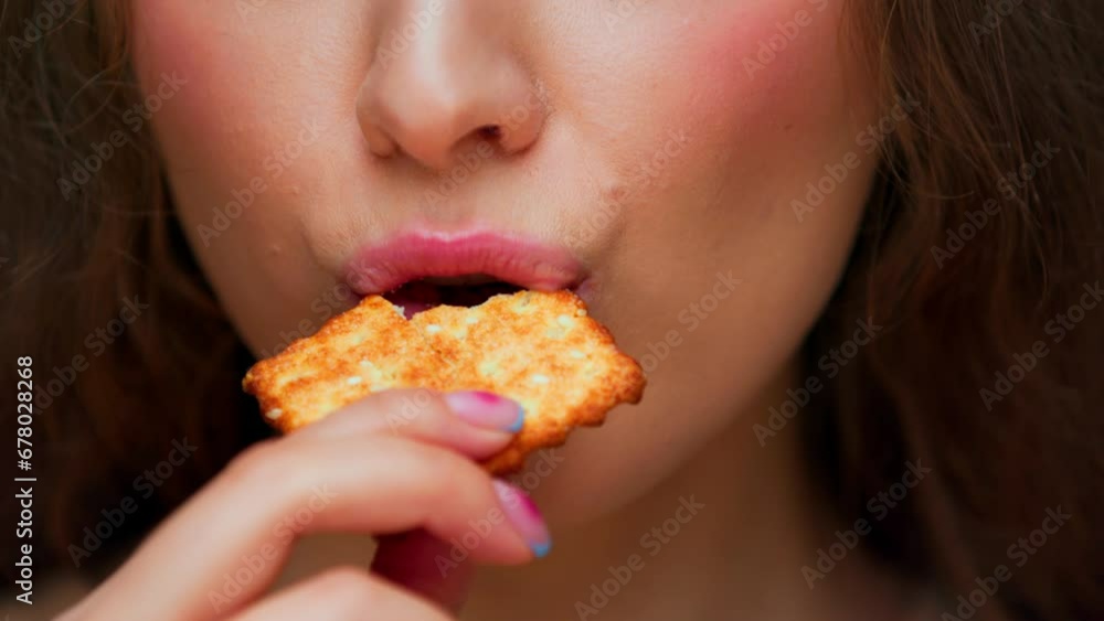 Portrait of Young Woman Eating Sweet Food on Camera Close Up. Crop Face of Modern Person Biting Crunchy Sesame Cookie in Mouth. Normal Appetite of Alone Hunger Lady with Crispy Treat in Studio Light Portrait of Young Woman Eating Sweet Food on Camera Close Up. Crop Face of Modern Person Biting Crunchy Sesame Cookie in Mouth. Normal Appetite of Alone Hunger Lady with Crispy Treat in Studio Light